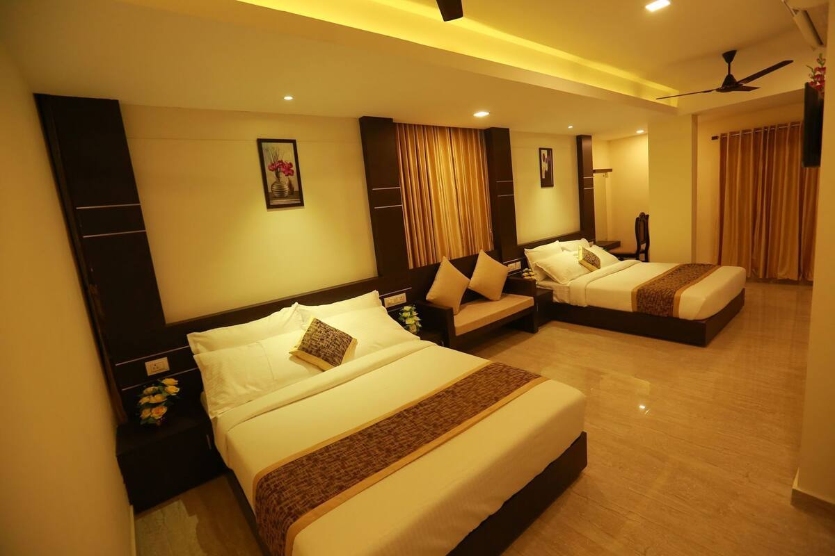 A hotel room with two beds, a large mirror, and a ceiling fan.