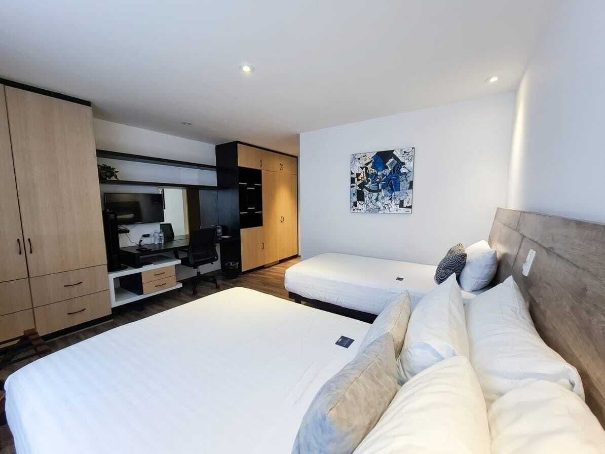 Habitación triple estándar, varias camas | Área de sala de estar | Smart TV de 36 pulgadas con canales por cable y televisión 