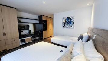 Habitación triple estándar, varias camas | Área de sala de estar | Smart TV de 36 pulgadas con canales por cable y televisión