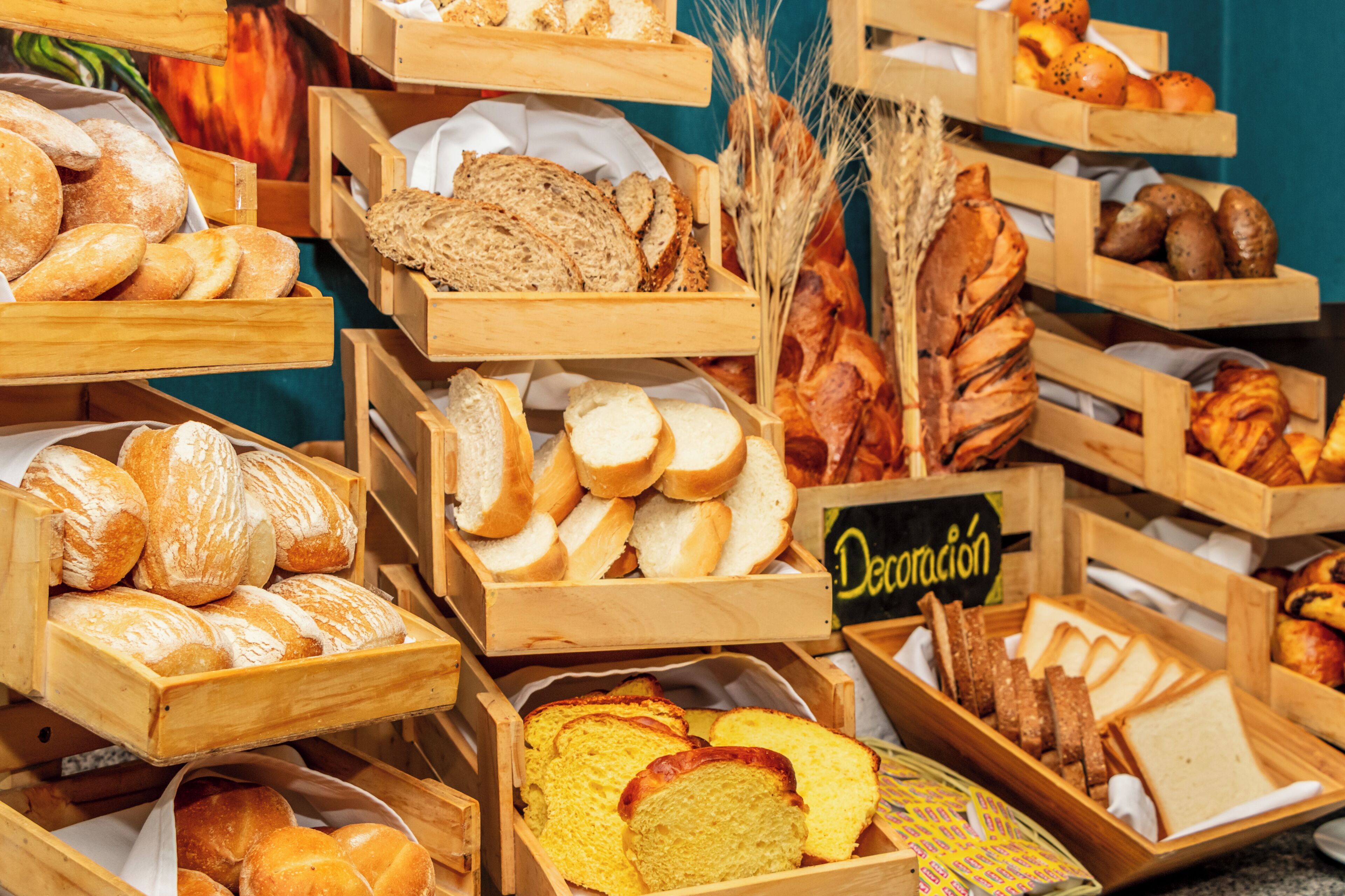 A variety of bread and pastries displayed in wooden crates.