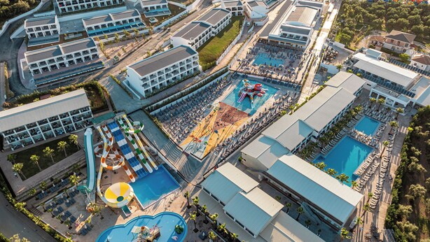 An aerial view of a resort with multiple swimming pools, a water park, and a variety of buildings. - Caretta Paradise Resort & Waterpark (Zakynthos)