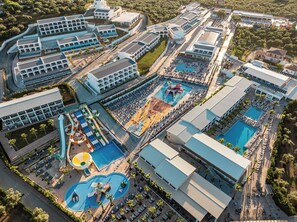 An aerial view of a resort with multiple swimming pools, a water park, and a variety of buildings. - Caretta Paradise Resort & Waterpark (Zakynthos)