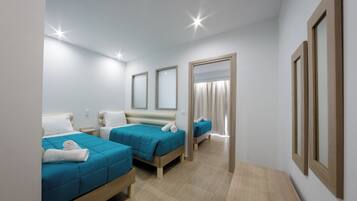 A hotel room with two beds, a wooden nightstand, a mirror, and a small table.