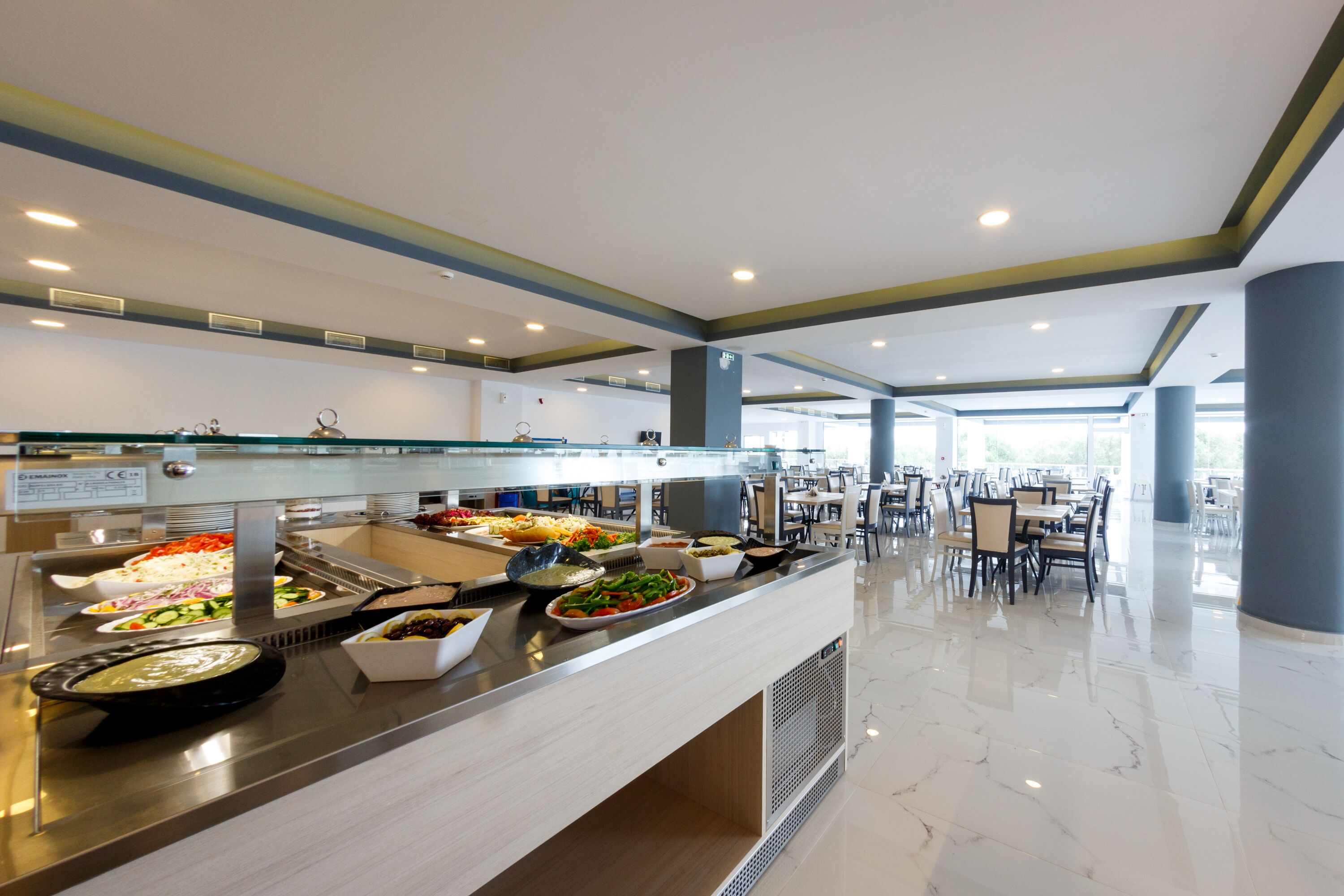 A buffet area with various food options and a seating area with tables and chairs.