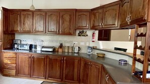 A kitchen with wooden cabinets, a countertop, and various appliances.