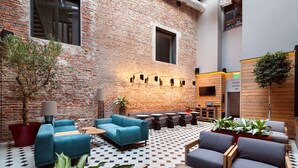 A modern lounge area with brick walls, a checkered floor, and contemporary furniture.