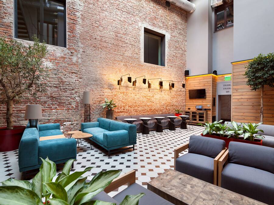 A modern lounge area with brick walls, a checkered floor, and contemporary furniture.