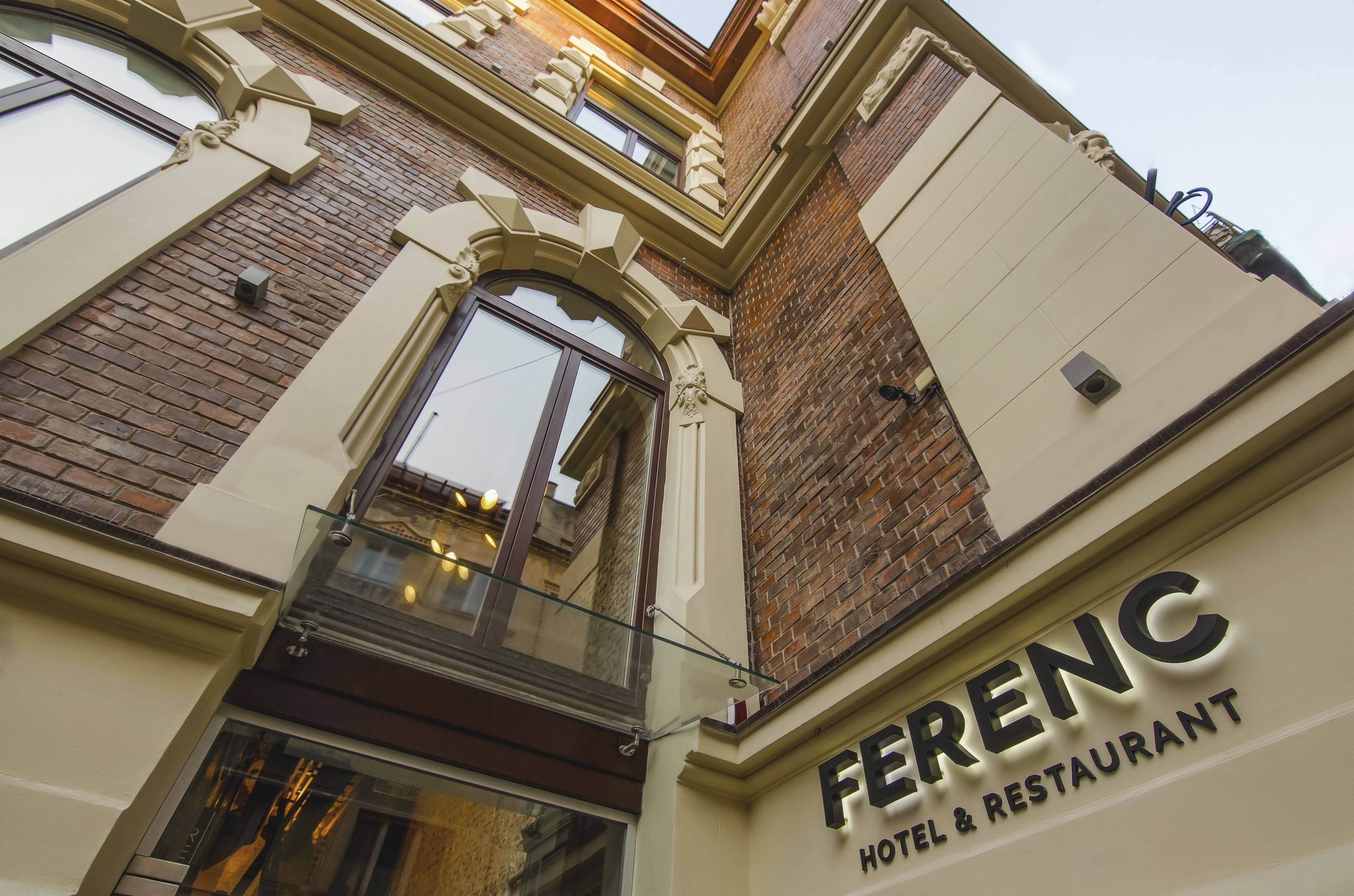 The exterior of Ferenc Hotel & Restaurant with a classic architectural style, featuring a prominent entrance and a glass facade.
