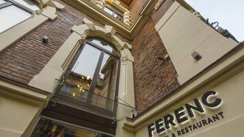 The exterior of Ferenc Hotel & Restaurant with a classic architectural style, featuring a prominent entrance and a glass facade.