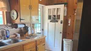 Una cocina con armarios de madera, un lavamanos y un refrigerador.