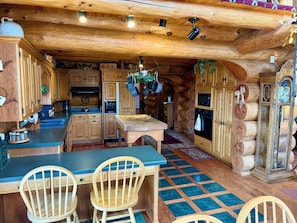 Una cucina rustica con mobili in legno, un'isola centrale e piante pensili.
