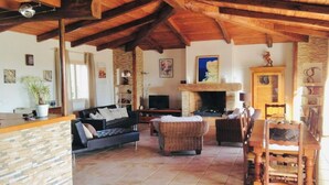 A spacious living area with a fireplace, stone walls, and wooden furniture. - Magnificent air-conditioned villa with private pool, 2 bedrooms 2 bathrooms (4 people) (Porto-Vecchio)