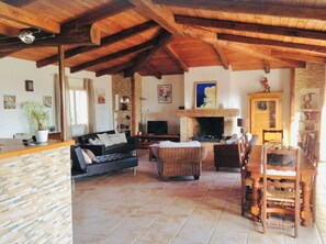 Cozy living area with a stone fireplace, comfortable seating, and a dining table.