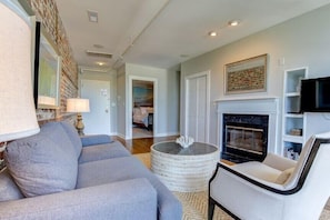 A living room with a fireplace, a sofa, a coffee table, and a television.