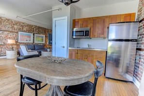Una cucina moderna con forno a microonde integrato, frigorifero in acciaio inox e mobili in legno.