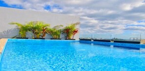 Alberca al aire libre y camastros