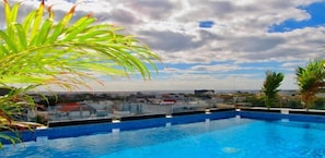 Alberca al aire libre y camastros