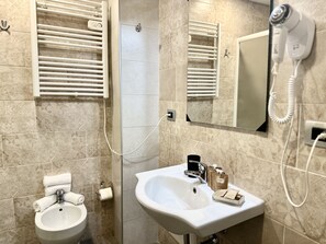 A bathroom with a sink, towel rack, and a hairdryer. - Hotel Giacosa (Milan)