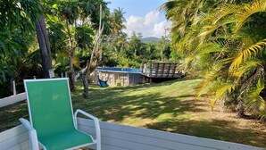 A wooden deck with a green chair and a white bench. - NATURE LOVER'S ESCAPE!-on 3200 acre reserve with miles of a "Cast A Way" beach.  (Punta Santiago)