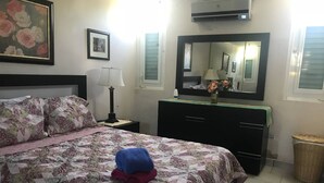 A bedroom with a bed, a dresser, a mirror, and a window. - NATURE LOVER'S ESCAPE!-on 3200 acre reserve with miles of a "Cast A Way" beach.  (Punta Santiago)