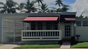 A building with a red awning, a gated entrance, and a balcony. - NATURE LOVER'S ESCAPE!-on 3200 acre reserve with miles of a "Cast A Way" beach.  (Punta Santiago)