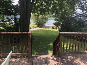 Eine Holzterrasse mit Blick auf eine Wiese und einen See.