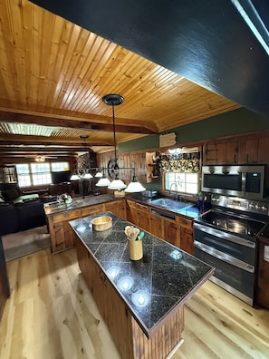 A spacious kitchen with wooden cabinets, a large island, and stainless steel appliances.