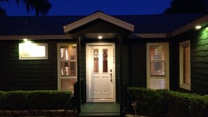 A house with a front door, two windows with blinds, and a small porch. - Lakefront Country Haven near Ocala & Forest -With Canoe, Lifejackets and Grill! (Ft McCoy)