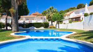A swimming pool with a tiled edge, surrounded by a white wall and greenery. - Charming house with sea views in Salou 015 Casas Blancas (Salou)
