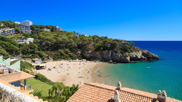 A coastal town with a beach, buildings on a hillside, and clear blue water. - Charming house with sea views in Salou 015 Casas Blancas (Salou)