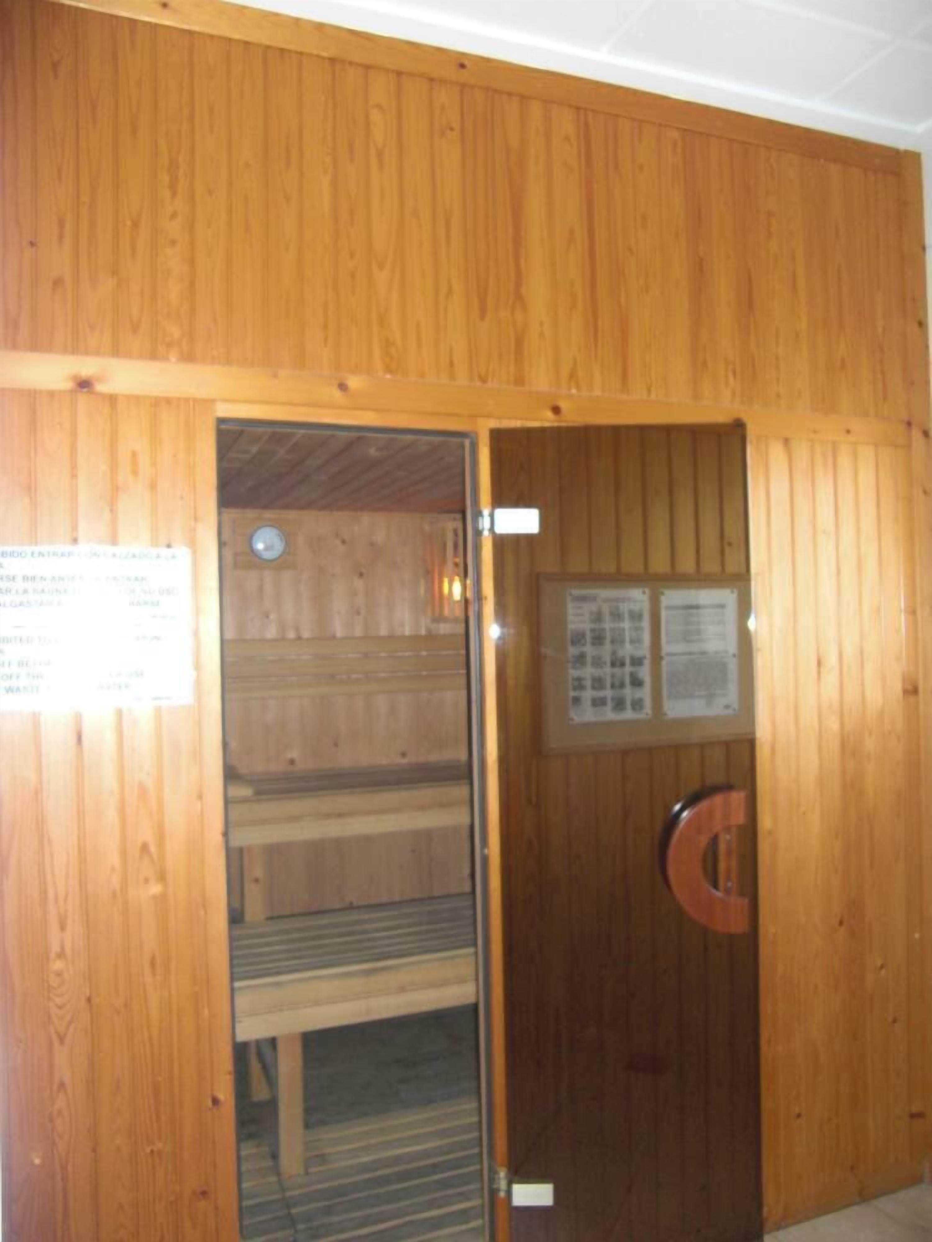 Ein Saunaraum mit Holzwänden und einer Glastür.