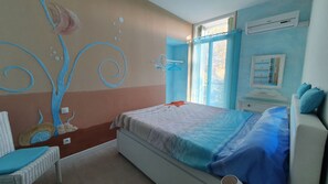 A bedroom with a bed, a chair, a dresser, and a wall mural.