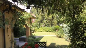A table set outdoors with a garden view, including a lawn and various plants. - Charming Villa with pool near Rome  (Sacrofano)