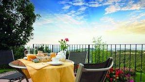 A table set with breakfast items on a balcony overlooking a scenic landscape. - Villa with pool 10 minutes from Vicenza, garden, privacy, panoramic view (Isola Vicentina)