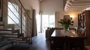 A modern interior with a staircase, dining area, and bookshelves. - Villa with pool 10 minutes from Vicenza, garden, privacy, panoramic view (Isola Vicentina)