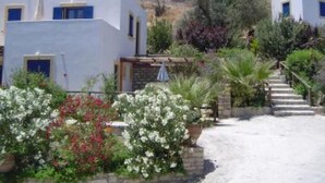 A white building with a garden and a staircase leading up. - Complex of apartments & studio, full-equipped, in a large, beautiful garden (Kamilari)