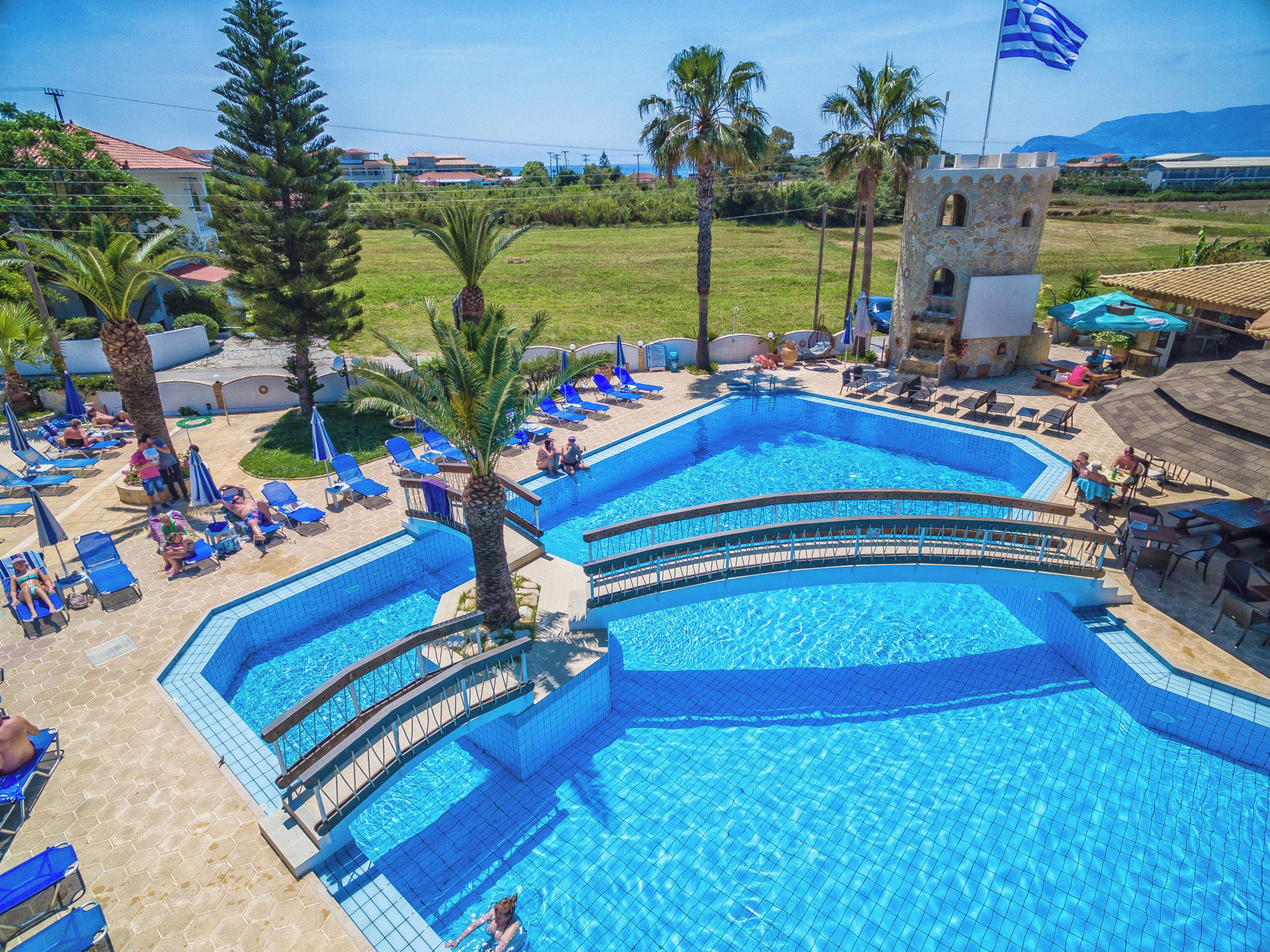 A swimming pool with multiple lanes, surrounded by lounge chairs and palm trees.