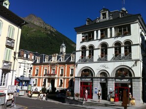 Un bâtiment historique doté d’une tour horlogée, d’une entrée rouge et d’une enseigne indiquant « Office de tourisme ».