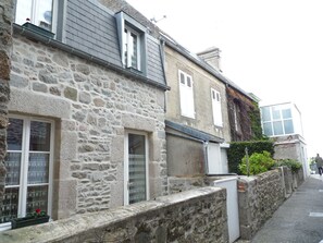 Traditional stone building with a classic facade, featuring multiple windows and a small balcony.