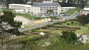 A large building with multiple floors, surrounded by a parking lot and greenery.