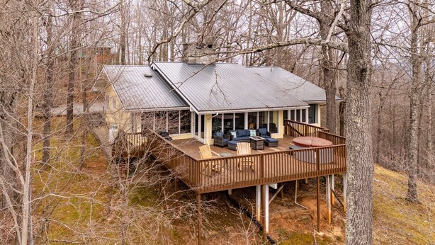 Une cabane dotée d’une terrasse, de sièges intégrés et d’un porche couvert.