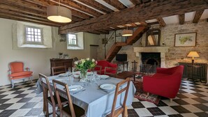 Un comedor con suelo de ajedrez, mobiliario de madera y chimenea.