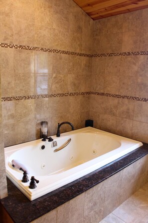 A modern bathroom with a freestanding bathtub, marble tiles, and a wooden ceiling. - Romantic Waterfront Suite With Amazing Water Views, Hedgehog unit (Ellison Bay)