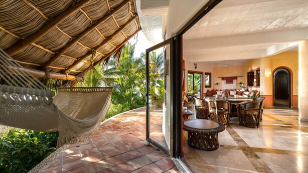 A room with a thatched roof, a hammock, a dining area with a round table, and a view of palm trees. - Secluded Beachfront Sanctuary w/ Epic Sunsets & Palapa Lounge (Higuera Blanca)