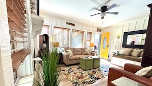 A living room with a sofa, coffee table, and a ceiling fan. - 🌊🌊 2026 @  the Pineapple Cottage. Steps to Ocean. 🌊 RELAX & ENJOY 😎the beach.⛱️🌊🌊 (Seal Beach)