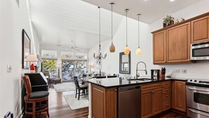 A modern kitchen with wooden cabinets, stainless steel appliances, and a large island.