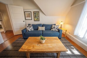 Relax in this inviting living room with a sofa, coffee table, and framed artworks.