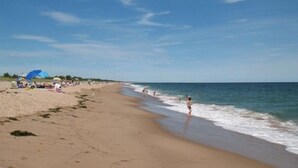 A beach with people walking along the shore, umbrellas, and a clear sky. - Stunning Sunsets on Quonnie Waterfront- 2 Kayaks, Beach Pass & Backyard Clamming (Charlestown)