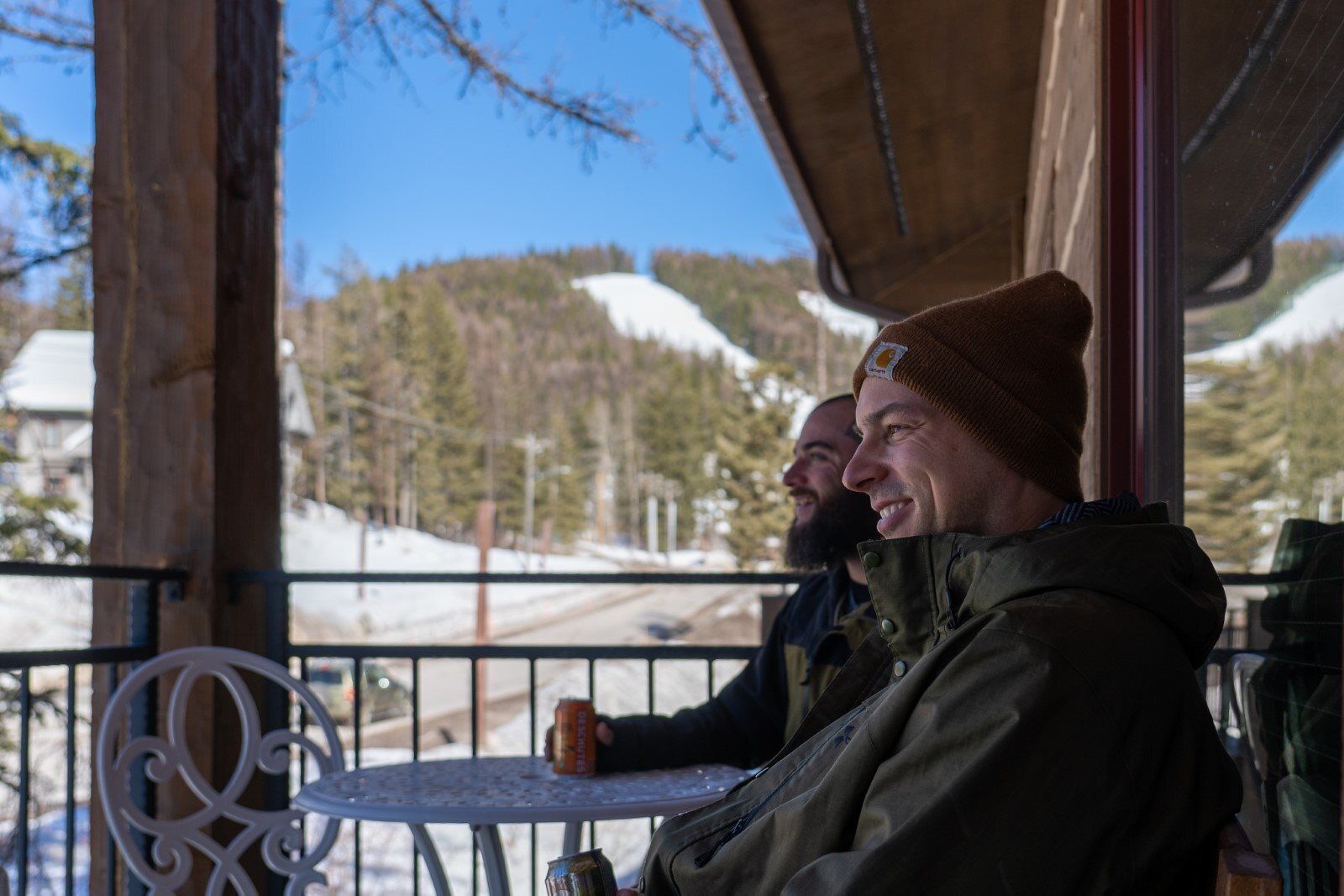 Two people seated at a table with a view of snow-covered mountains.