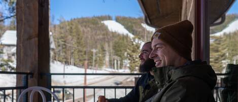 Two people seated at a table with a view of snow-covered mountains.
